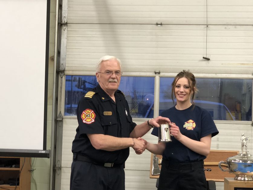  Zaynah Chomas, right, is the newest Drumheller Firefighter. She passed her six-month probation and is presented her mug by Chief Bruce Wade.