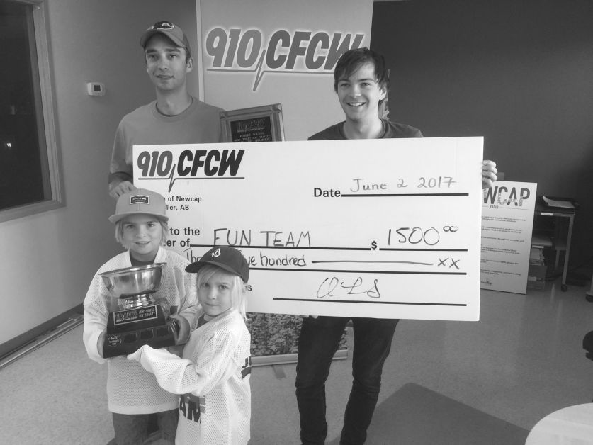   Champion Mini-chucks driver Robert Wilson, (left), accepts a $1,500 cheque from CFCW afternoon host Luca James Tuesday morning August 29, having won the station’s MIni-Chuck’s for charity event held at Freson Market in June. Wilson’s sponsor was Tower Trophies, and owner Nicky Sereda decided to donate the money to Drumheller’s FunTeam. Players Nate and Fraser hold up the champion’s trophy, and told the Mail the funds will be put toward ice fees for FunTeams, now in their 18th season in Drumheller. mailphoto by O.R. Sheddy, Mail Editor